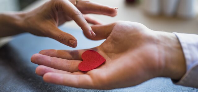 man_giving_red_ornament_heart_woman